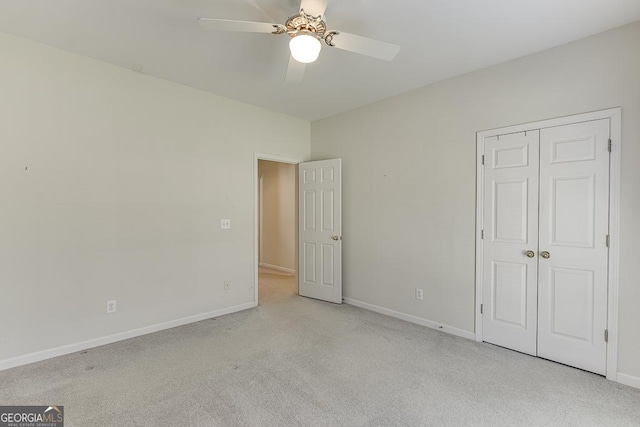 unfurnished bedroom featuring carpet floors, baseboards, a closet, and a ceiling fan