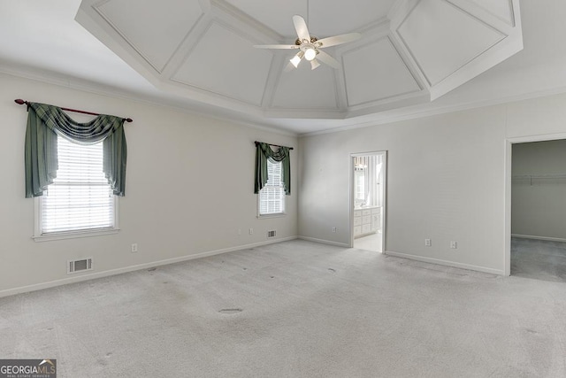 unfurnished bedroom featuring attic access, coffered ceiling, ornamental molding, carpet, and a walk in closet