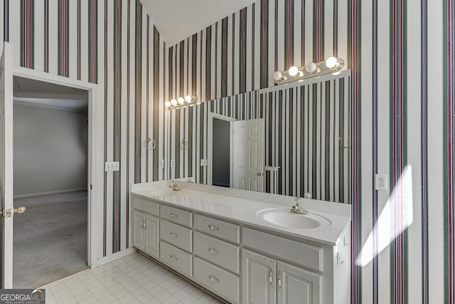 full bath with wallpapered walls, baseboards, double vanity, and tile patterned floors