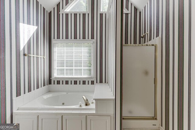 bathroom with wallpapered walls, a shower stall, plenty of natural light, and a whirlpool tub