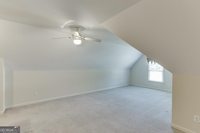 additional living space featuring light carpet, baseboards, ceiling fan, and lofted ceiling