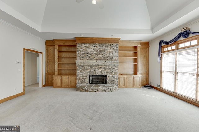 unfurnished living room featuring built in shelves, baseboards, light colored carpet, a fireplace, and crown molding