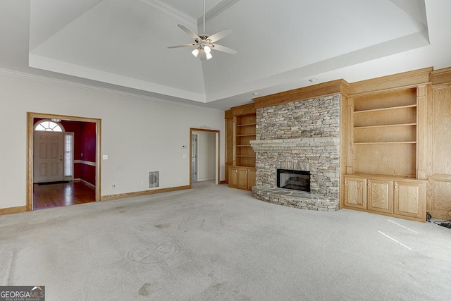 unfurnished living room with carpet, a raised ceiling, baseboards, a ceiling fan, and ornamental molding