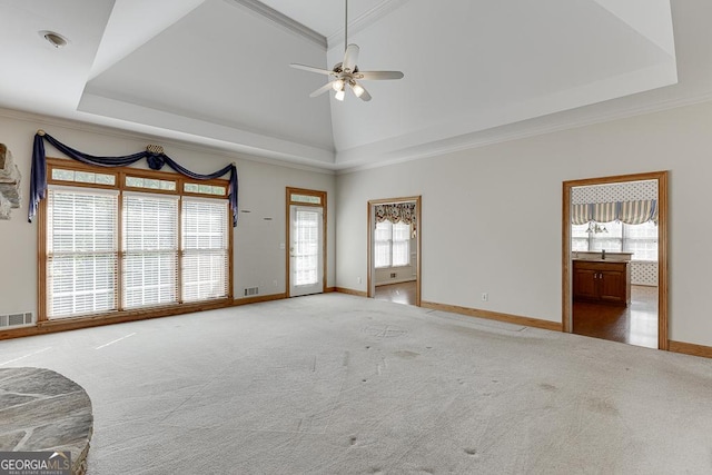 unfurnished living room featuring plenty of natural light, baseboards, carpet floors, ceiling fan, and crown molding