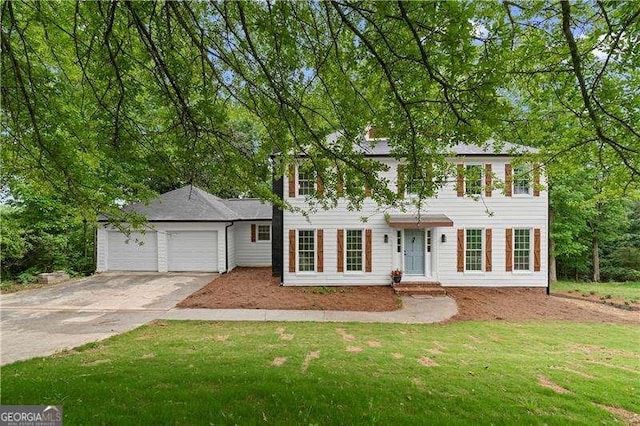 colonial inspired home with an attached garage, a front yard, and concrete driveway