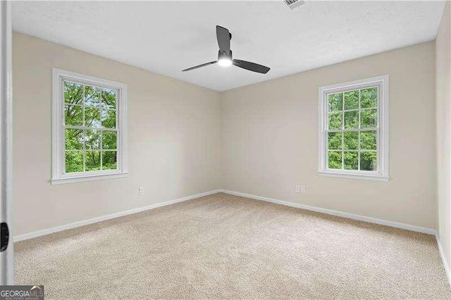 empty room with carpet, ceiling fan, and plenty of natural light