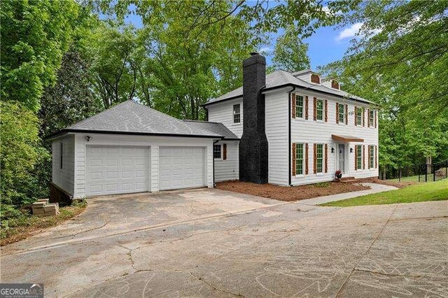 view of front of home with driveway and a chimney
