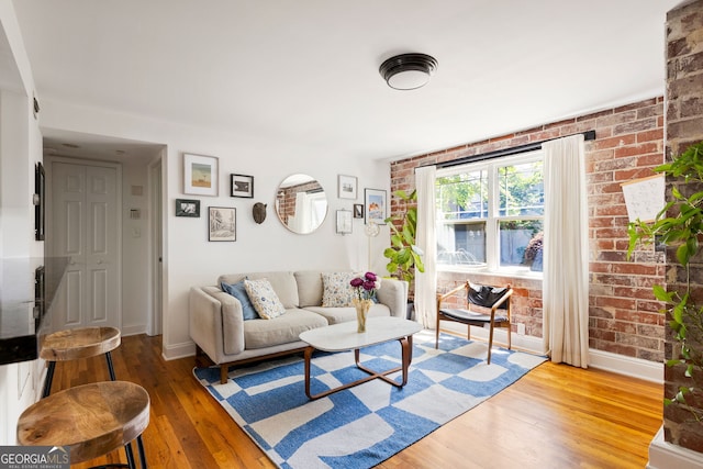 24 Daniel St SE # 3, Atlanta, GA 30312 - living area with hardwood / wood-style flooring, brick wall, and baseboards