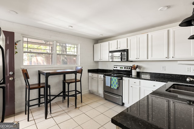 24 Daniel St SE # 3, Atlanta, GA 30312 - kitchen with appliances with stainless steel finishes, a sink, white cabinetry, and light tile patterned floors