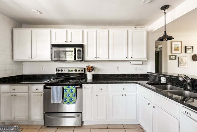 24 Daniel St SE # 3, Atlanta, GA 30312 - kitchen with stainless steel appliances, dark stone countertops, a sink, light tile patterned flooring, and white cabinetry