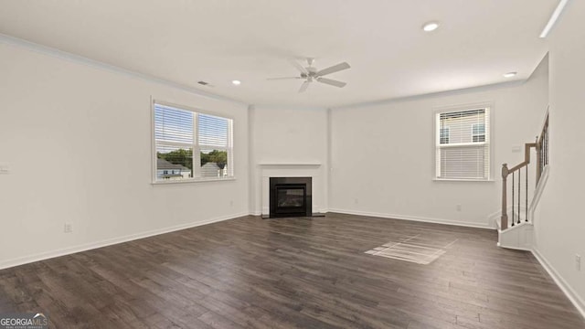 1109 Blue Juniper Cir, Loganville, GA 30052 - unfurnished living room featuring ceiling fan, stairway, dark wood-style flooring, a glass covered fireplace, and recessed lighting
