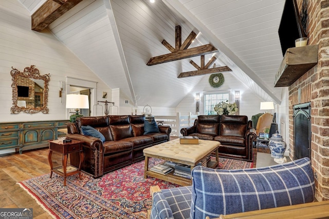 living area featuring wood walls, wood finished floors, and vaulted ceiling with beams