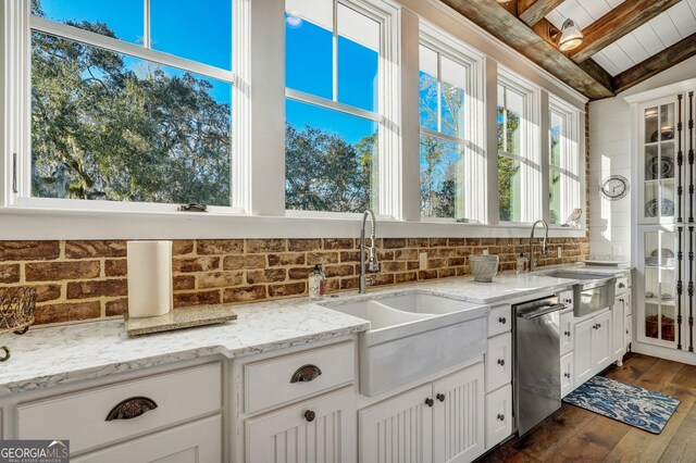 kitchen with dishwasher, a sink, vaulted ceiling with beams, and tasteful backsplash