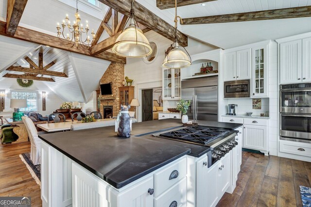kitchen with built in appliances, lofted ceiling with beams, dark wood-type flooring, dark countertops, and white cabinets