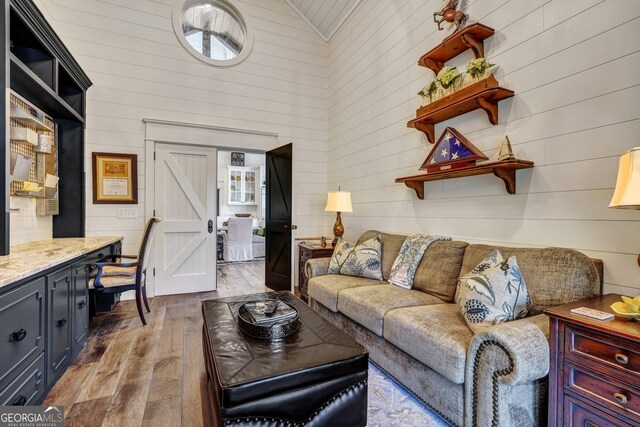 living room with wood walls, high vaulted ceiling, and wood-type flooring