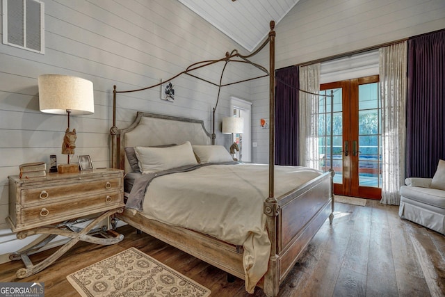 bedroom featuring visible vents, wooden walls, french doors, high vaulted ceiling, and access to outside