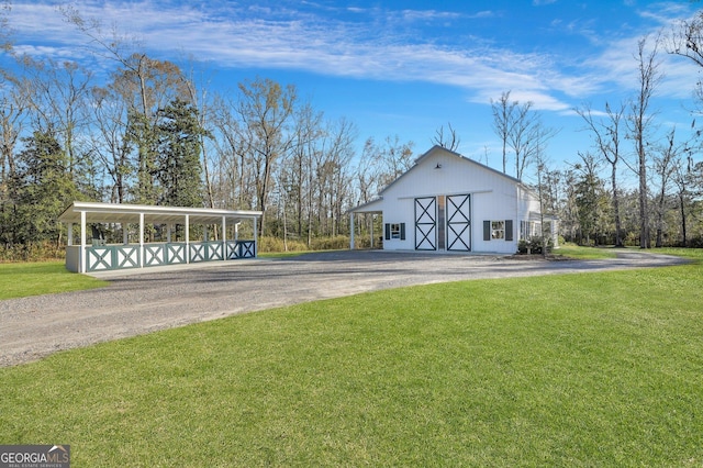 view of barn featuring a yard and dirt driveway