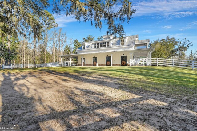 rear view of house featuring fence and metal roof