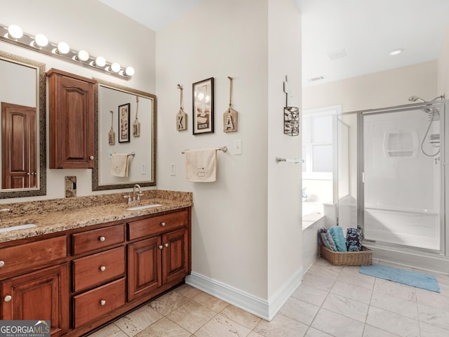 full bathroom with a shower stall, a bath, baseboards, and double vanity