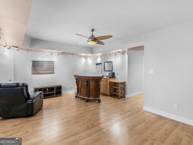 office area featuring track lighting, ceiling fan, light wood-style flooring, and baseboards
