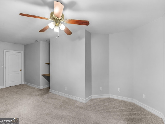 carpeted empty room featuring ceiling fan and baseboards