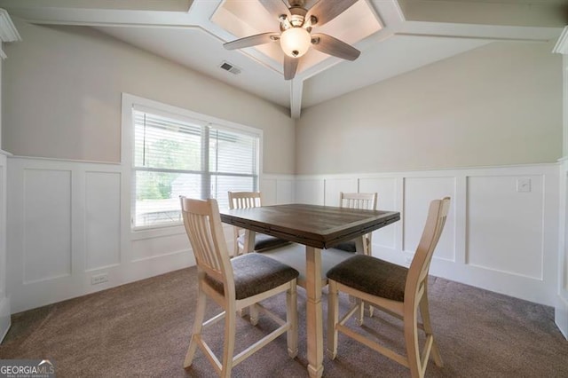 carpeted dining area with a decorative wall, ceiling fan, vaulted ceiling, and a wainscoted wall