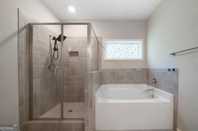full bathroom featuring a bath and a stall shower