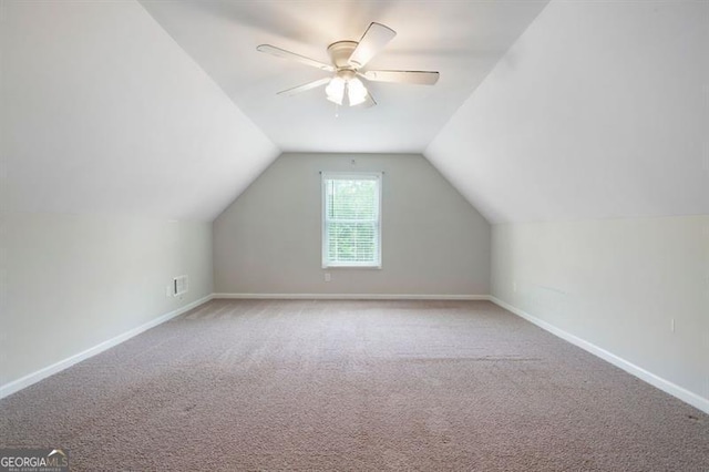 additional living space with carpet floors, lofted ceiling, a ceiling fan, and baseboards