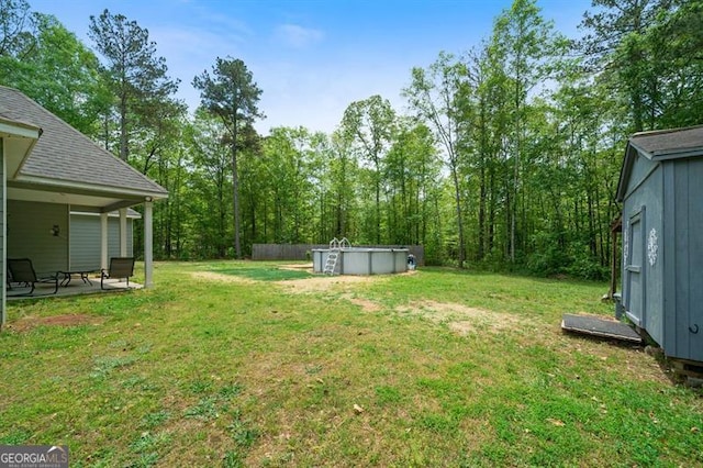 view of green lawn featuring an outdoor pool and a patio area