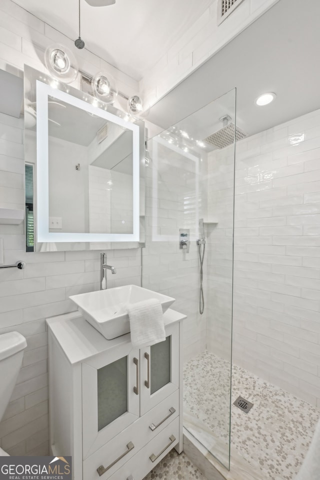 285 Lakemoore Dr NE Unit A, Atlanta, GA 30342 - full bathroom with visible vents, toilet, vanity, a walk in shower, and tile walls
