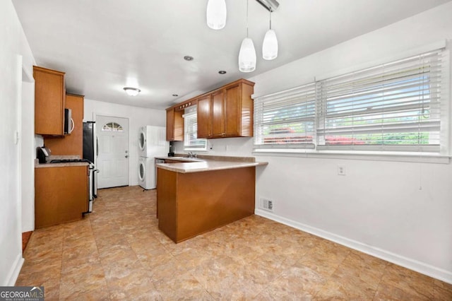 3050 Rebecca Dr SW, Atlanta, GA 30311 - kitchen featuring stacked washer / dryer, brown cabinetry, a peninsula, white appliances, and light countertops