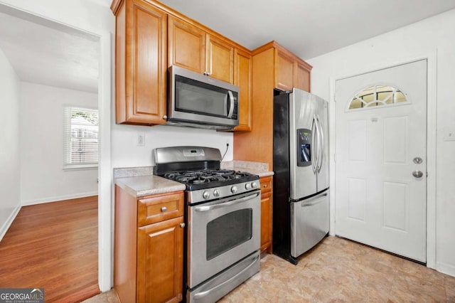 3050 Rebecca Dr SW, Atlanta, GA 30311 - kitchen with stainless steel appliances, light countertops, and brown cabinets