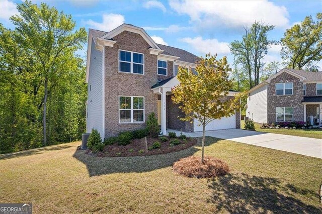 312 Wichita Way, Mcdonough, GA 30253 - traditional-style home featuring brick siding, an attached garage, driveway, and a front lawn