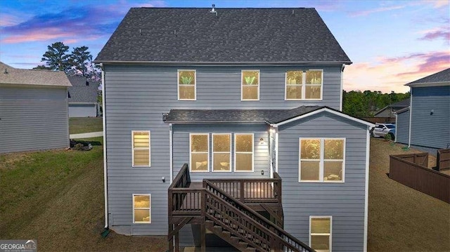 312 Wichita Way, Mcdonough, GA 30253 - back of property at dusk featuring a yard, a shingled roof, stairs, and a deck