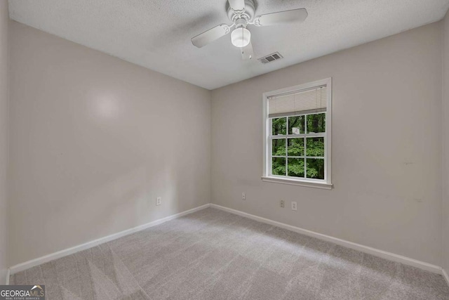 carpeted spare room featuring baseboards and visible vents