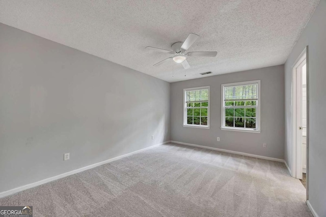 empty room with ceiling fan, carpet floors, a textured ceiling, and baseboards