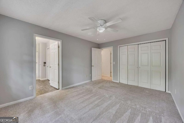 unfurnished bedroom with baseboards, carpet flooring, and a closet