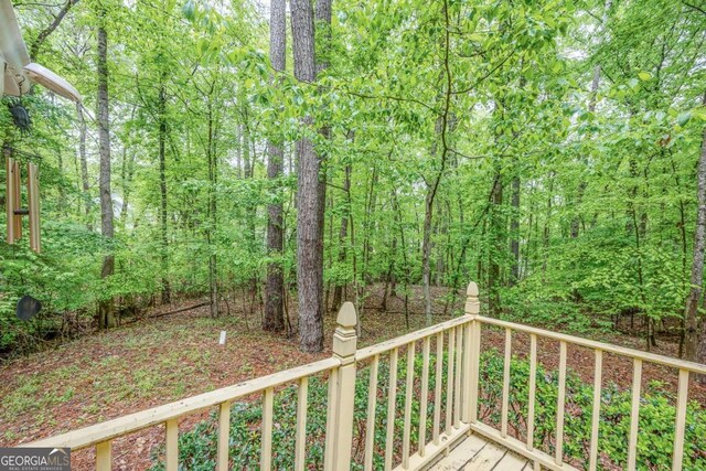 wooden deck with a wooded view