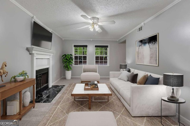 living room with a fireplace with flush hearth, a textured ceiling, ceiling fan, and crown molding