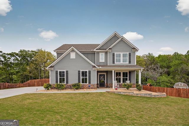 craftsman inspired home with fence, a shingled roof, board and batten siding, covered porch, and a front yard