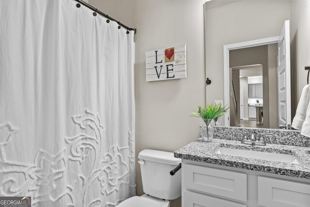 bathroom with toilet, vanity, and curtained shower