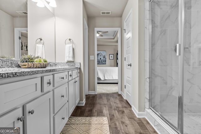 ensuite bathroom featuring wood finished floors, vanity, ensuite bath, a stall shower, and ceiling fan