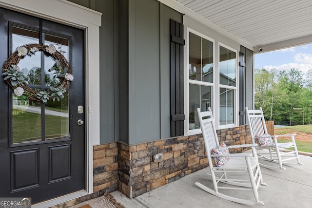 property entrance featuring a porch and stone siding