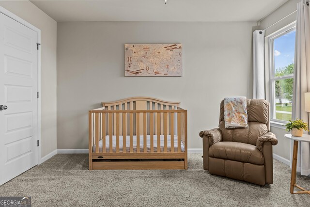carpeted bedroom with a nursery area and baseboards