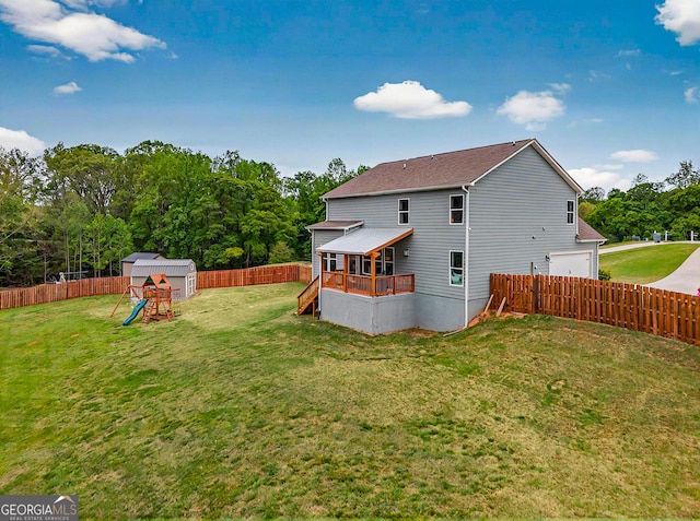 back of house with a fenced backyard, a playground, a wooden deck, an attached garage, and stairs