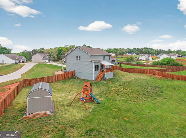 view of yard featuring a fenced backyard, a residential view, and a playground