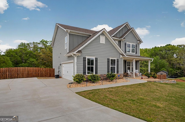 craftsman inspired home featuring fence, a storage shed, concrete driveway, a porch, and a front yard