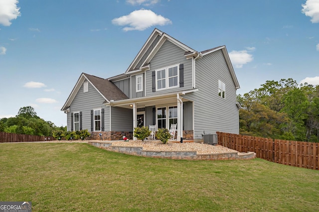 craftsman-style home featuring fence, a front yard, and central air condition unit