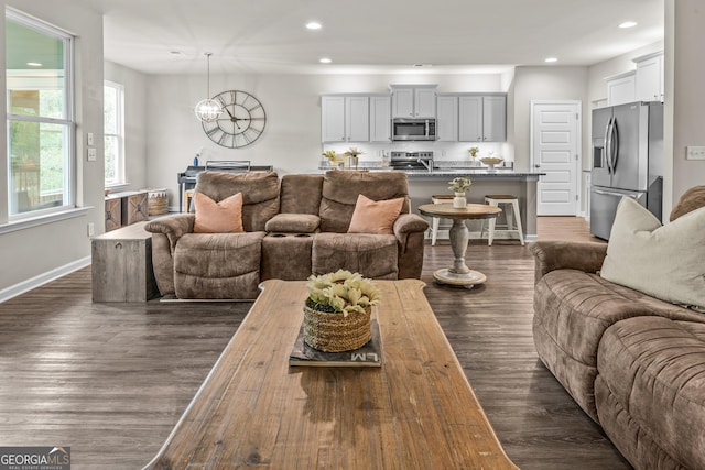 living area featuring baseboards, a chandelier, dark wood-type flooring, and recessed lighting