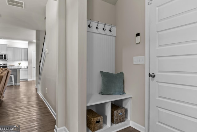 mudroom featuring baseboards, dark wood-type flooring, and visible vents